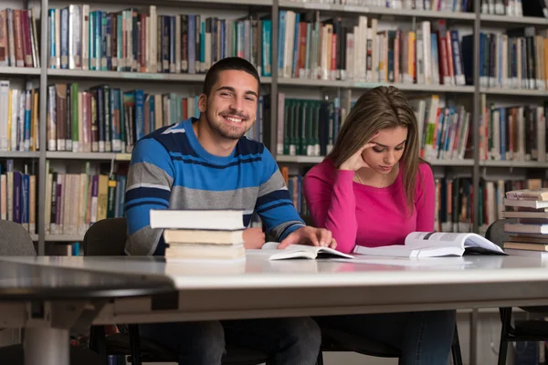 Grupo de jóvenes estudiantes sentados en la biblioteca —  Fotos de Stock