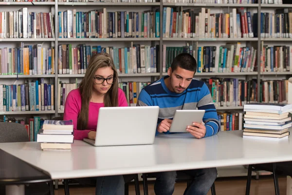 Glada studenter som arbetar med Laptop i biblioteket — Stockfoto