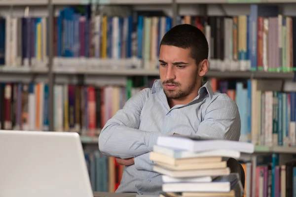 Estudiante estresado haciendo su tarea en el escritorio — Foto de Stock