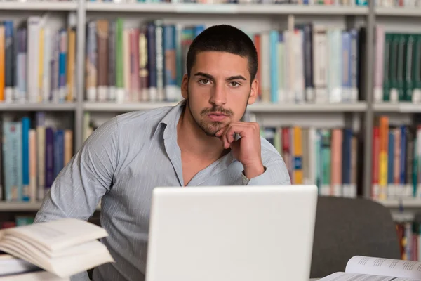 Estudiante estresado haciendo su tarea en el escritorio — Foto de Stock