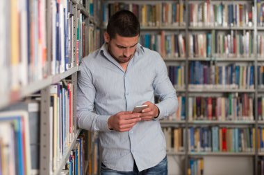 Cep telefonunda yazarak yakışıklı erkek üniversite öğrencisi