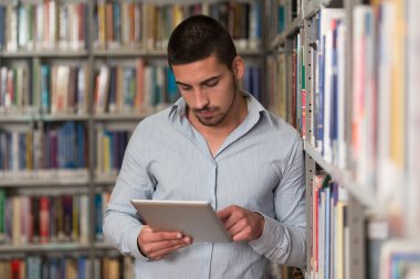 Kütüphane içinde Laptop ile mutlu erkek öğrenci