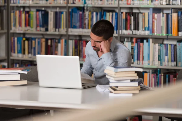 Estudiante masculino confundido leyendo muchos libros para el examen —  Fotos de Stock