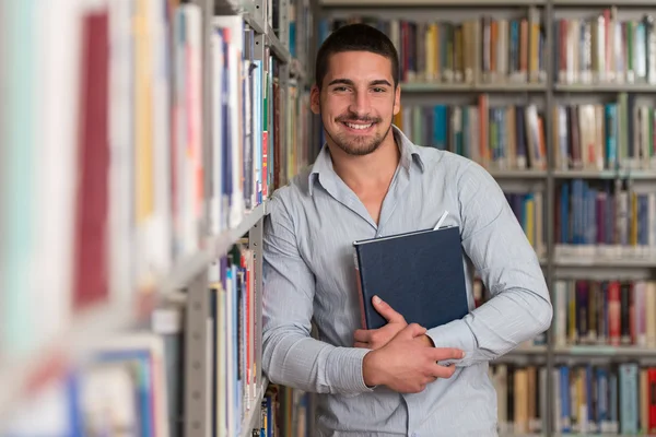 Pohledný mladý vysokoškolský Student v knihovně — Stock fotografie