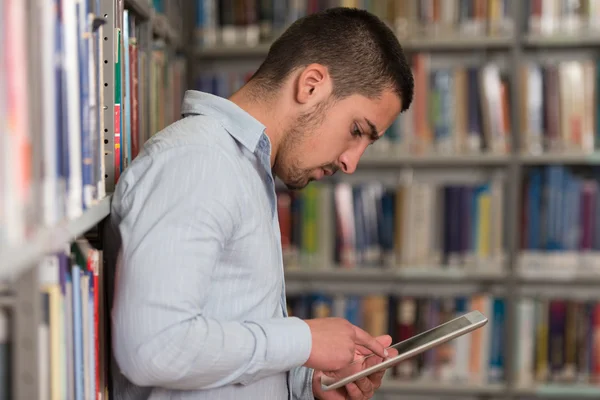 Studente che utilizza un computer tablet in una libreria — Foto Stock