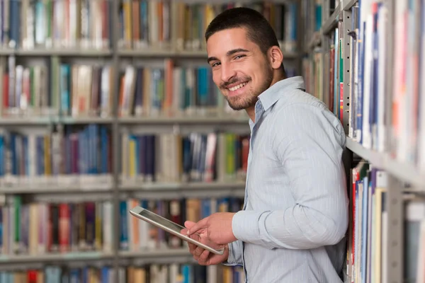 Ung Student med sin Laptop i ett bibliotek — Stockfoto