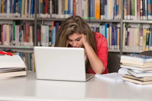 Estudante feminina confusa lendo muitos livros para exame — Fotografia de Stock