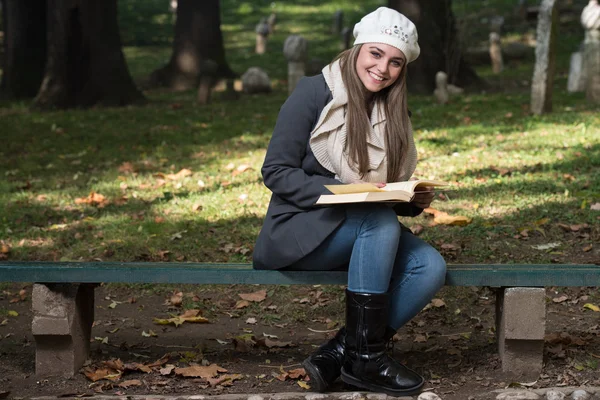 Mujer sentada en un parque y leyendo un libro —  Fotos de Stock