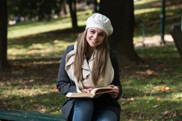 Mladá žena s knihou v parku — Stock fotografie