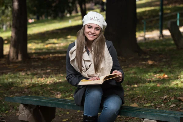 Aantrekkelijke vrouw leest het boek In Autumn Forest — Stockfoto