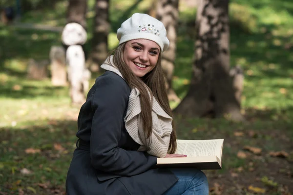 Hermosa joven leyendo libro en el parque —  Fotos de Stock