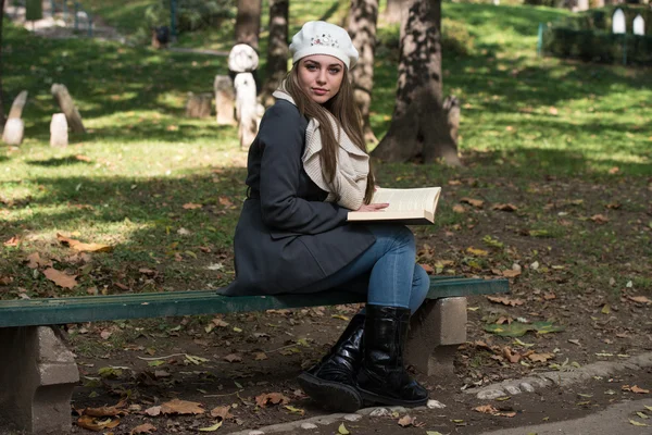 Junge Frau liest im Park ein Buch — Stockfoto