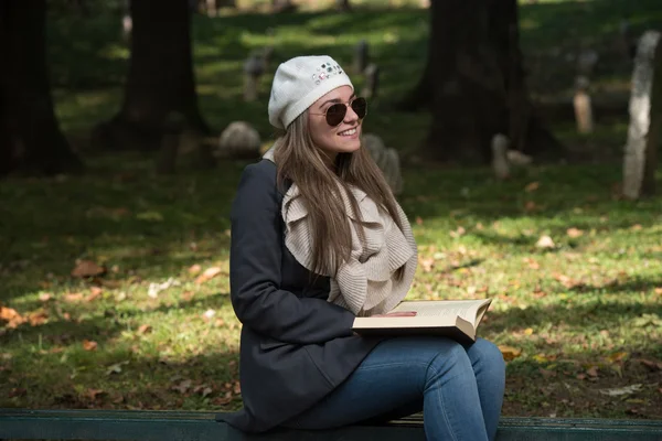 Hermosa joven leyendo libro en el parque —  Fotos de Stock