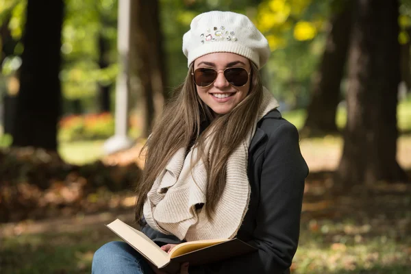 Hermosa joven leyendo libro en el parque —  Fotos de Stock