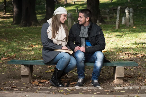 Jovem casal romântico no parque e livro de leitura — Fotografia de Stock