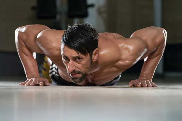 Jonge man doen pers ups in gym — Stockfoto