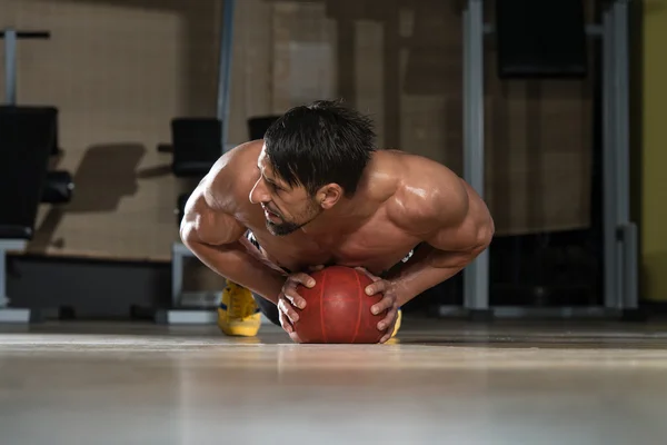 Jonge Man uitoefening push-ups op medicijnbal — Stockfoto