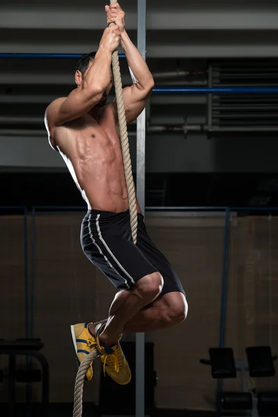 Fitnesssportler klettert am Seil — Stockfoto