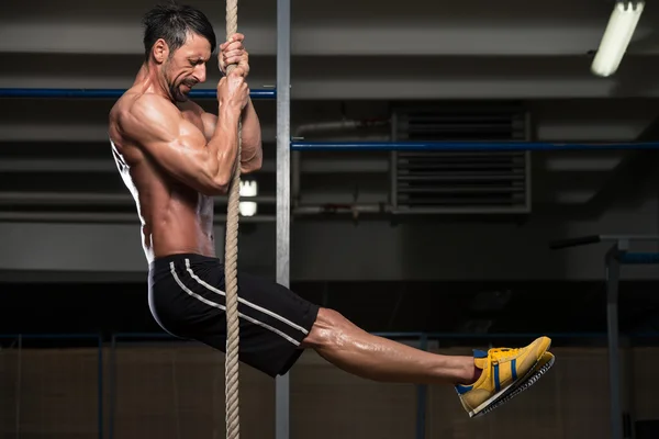 Joven escalando una cuerda — Foto de Stock