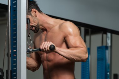 Kaslı adam trisepsler için ağır ağırlık egzersizi yapıyor.