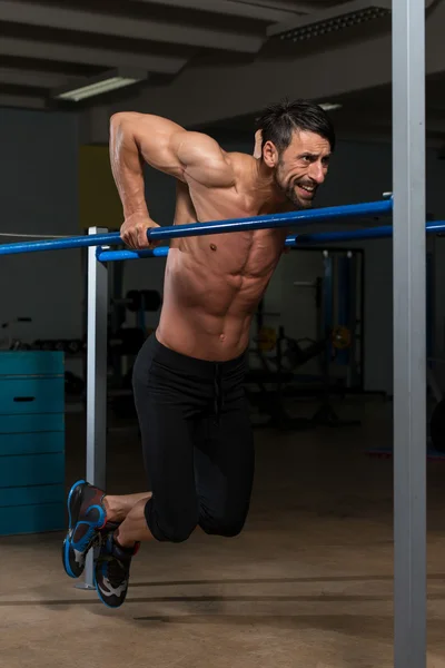 Atleta haciendo ejercicio de peso pesado en barras paralelas —  Fotos de Stock