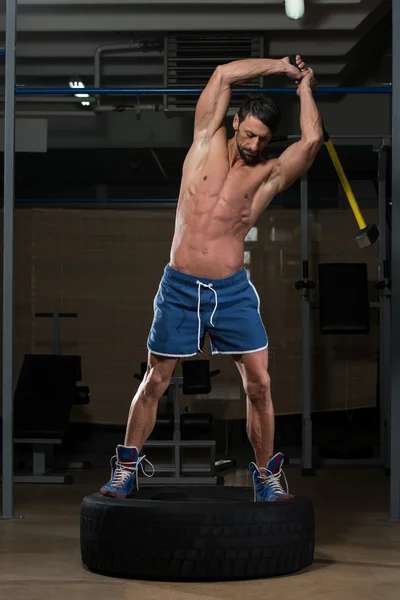 Athletic Man Hits Tire — Stock Photo, Image