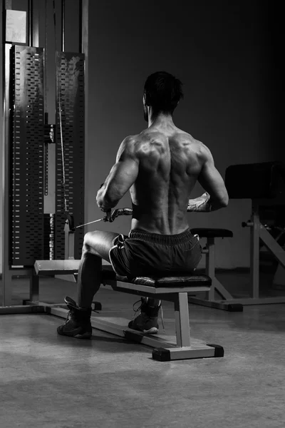 Joven haciendo ejercicios de espalda en el gimnasio —  Fotos de Stock