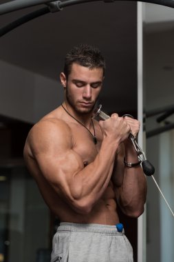 Kaslı adam pazılar için ağır ağırlık egzersizi yapıyor.