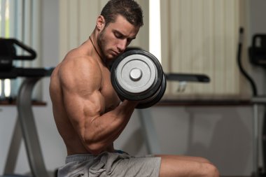 genç erkek spor salonunda pazı egzersizleri yapıyor