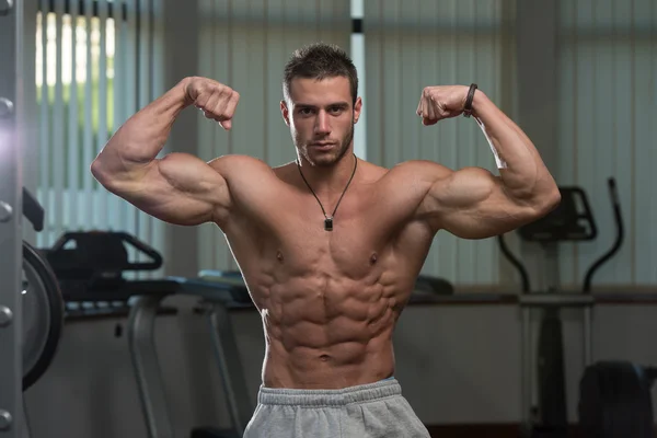 Jeune homme effectuant avant biceps double pose — Photo