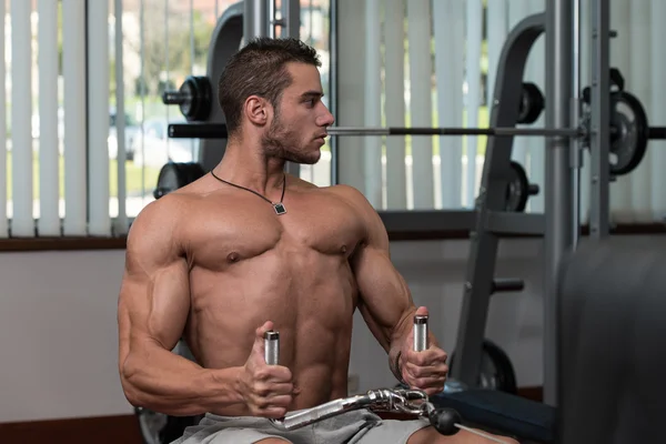 Joven haciendo ejercicios de espalda en el gimnasio — Foto de Stock