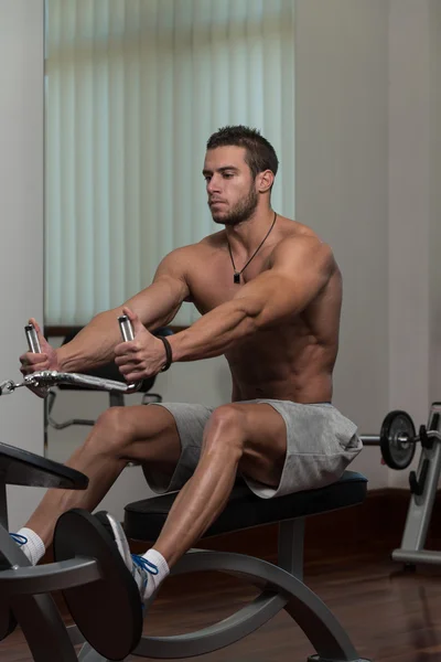 Ung Man gör ryggen övningar i gymmet — Stockfoto