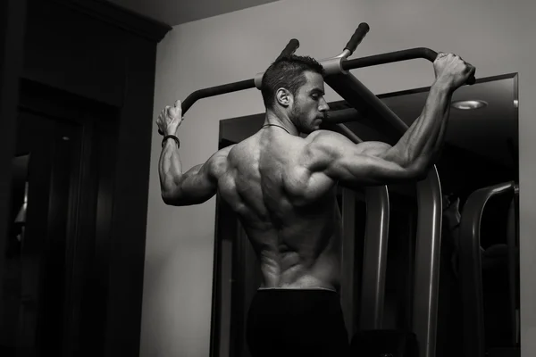 Joven haciendo ejercicios de espalda en el gimnasio —  Fotos de Stock