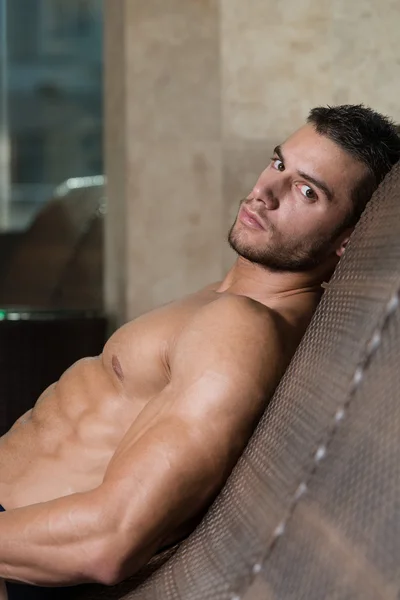 Homme reposant sur des chaises longues près de la piscine — Photo