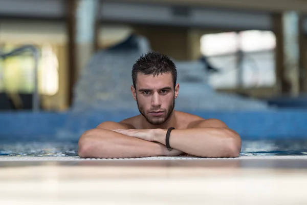 Nadador masculino descansando na piscina — Fotografia de Stock