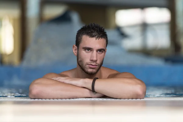 Homme se reposant détendu sur le bord de la piscine — Photo