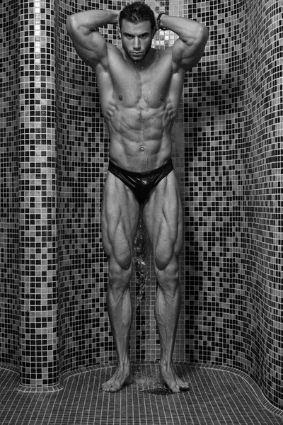 Junger gut aussehender Mann unter der Dusche im Bad — Stockfoto