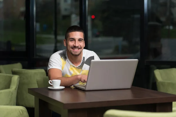 Glückliche Studentin im Café mit Laptop — Stockfoto