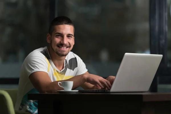 Heureux mâle étudiant dans café avec ordinateur portable — Photo