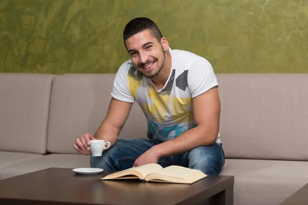 Feliz estudiante masculino en café con libro — Foto de Stock