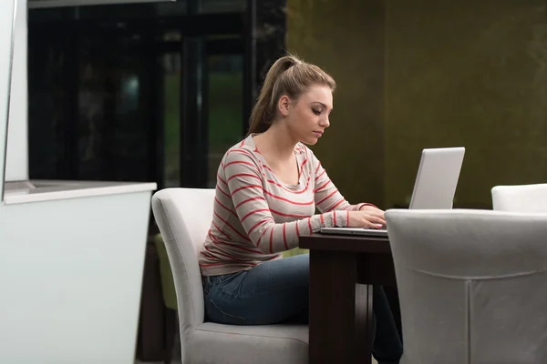 Feliz estudiante femenina en el café con el ordenador portátil —  Fotos de Stock