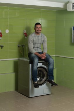 Genç adam ev işleri Çamaşırhane yapıyor