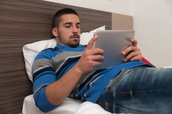 Zadowolony mężczyzna nastolatek za pomocą laptopa na tabletki — Zdjęcie stockowe