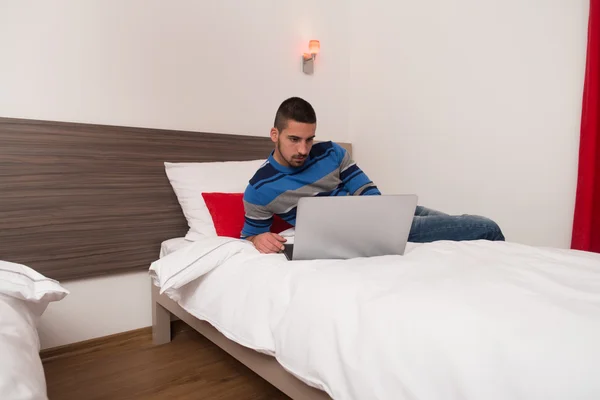 Happy Male Student In Bedroom With Laptop — Stock Photo, Image