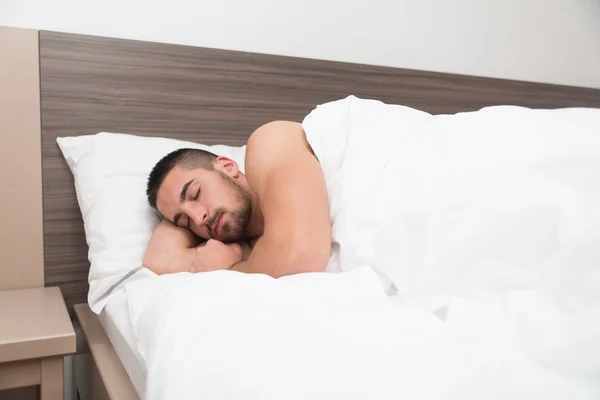 Junger Mann schläft friedlich in seinem eigenen Bett — Stockfoto