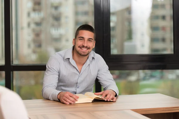 Tonåring läser en bok i biblioteket — Stockfoto