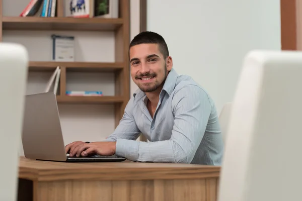 Heureux étudiant masculin dans la bibliothèque avec ordinateur portable — Photo