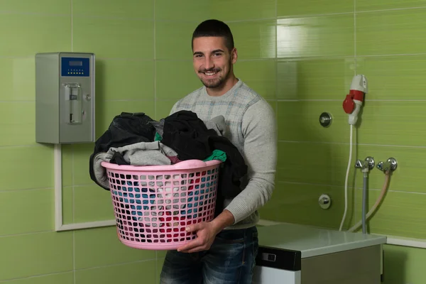 Giovane uomo che fa i lavori domestici lavanderia — Foto Stock