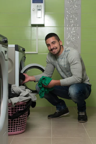 Όμορφος χαμογελαστός άνθρωπος στο δωμάτιο πλυντηρίων — Φωτογραφία Αρχείου
