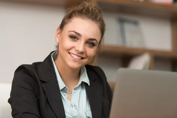 Happy Female Student In Library With Laptop Stock Photo